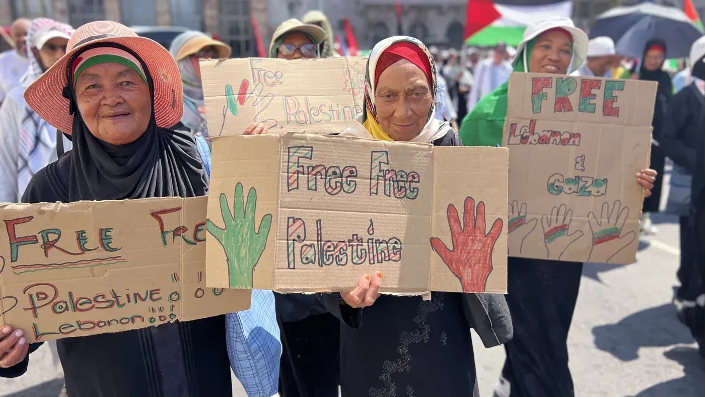 نساء يحملن لافتات تطالب بتحرير فلسطين ولبنان وغزة خلال احتجاج في جنوب إفريقيا، تعبيرًا عن التضامن مع القضية الفلسطينية.