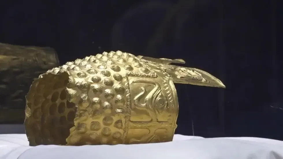 خوذة ذهبية مزخرفة تعود لحضارة الداقيين، معروضة في خزانة زجاجية بمتحف في بوخارست بعد استعادتها من هولندا.