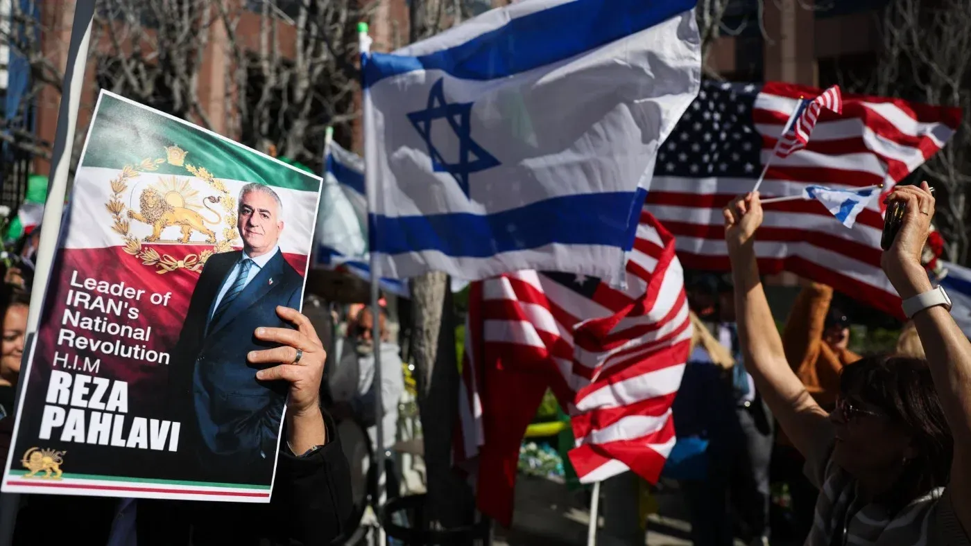 لافتة تحمل صورة رضا بهلوي، مع أعلام إسرائيل وأمريكا، خلال تجمع لدعم المعارضة الإيرانية في الشتات.