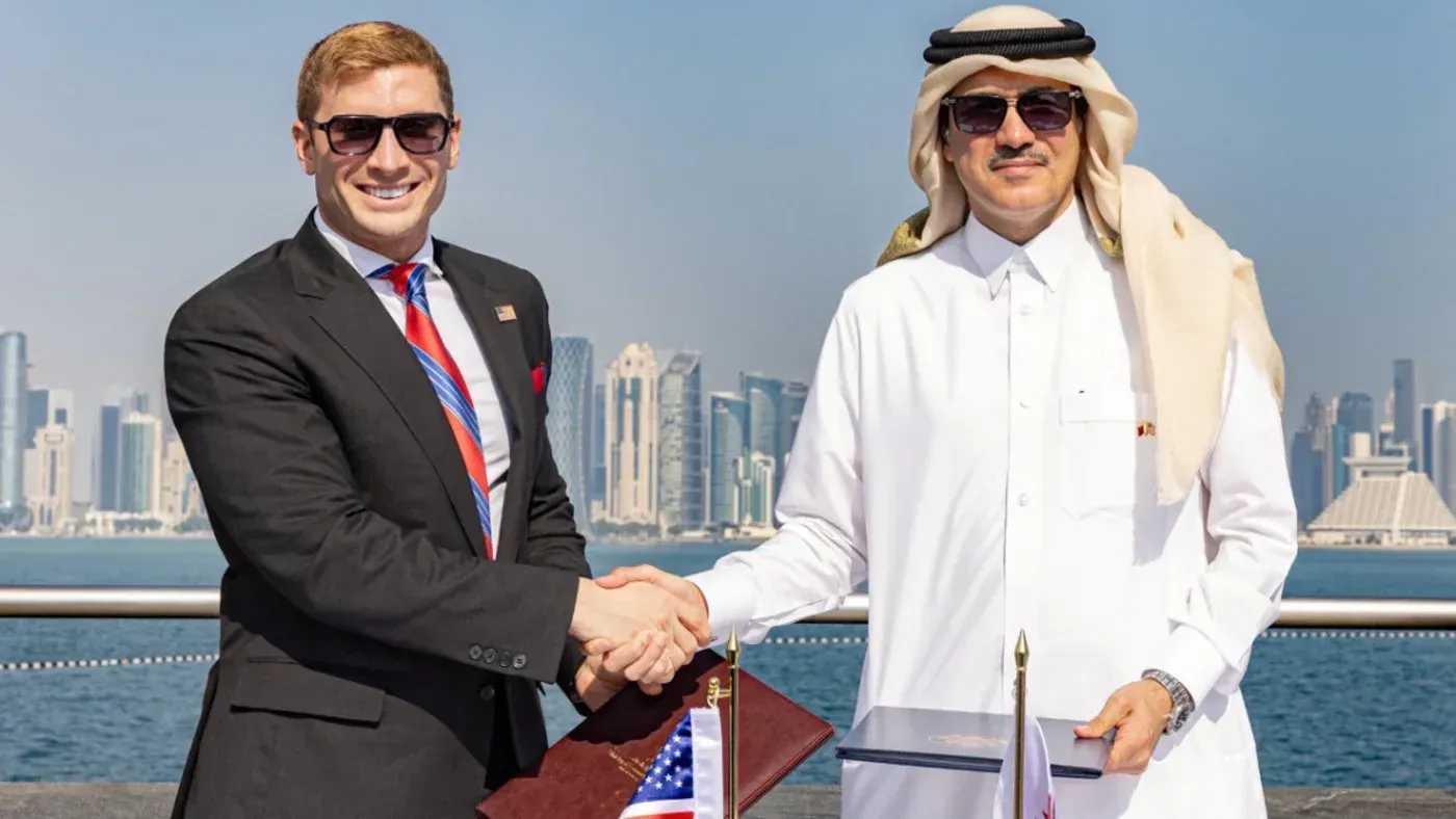 توقيع اتفاقية بين ممثلين عن قطر والولايات المتحدة لتعزيز التعاون في مجالات الذكاء الاصطناعي وسلاسل التوريد، مع خلفية مدينة الدوحة.