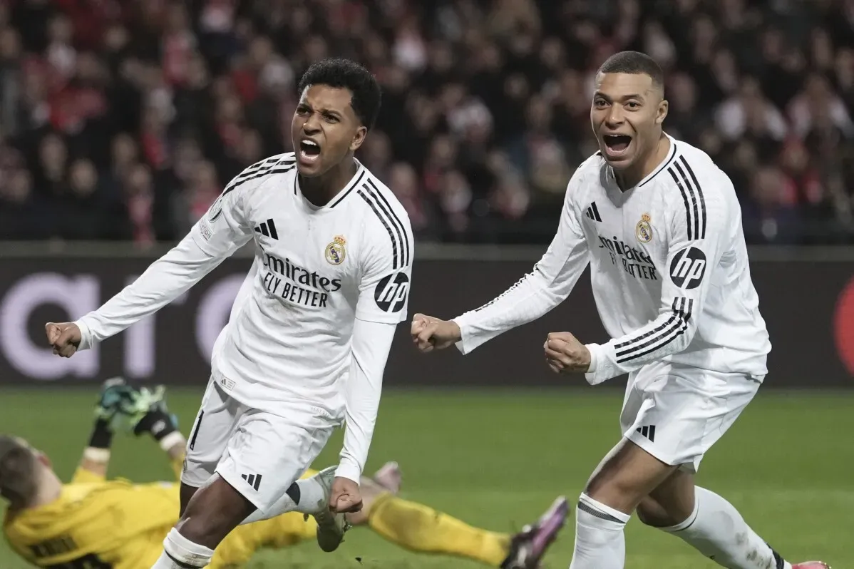 فرحة لاعبي ريال مدريد بعد تسجيل هدف، حيث يحتفل رودريغو ومبابي في مباراة حاسمة، في سياق منافسات دوري أبطال أوروبا.