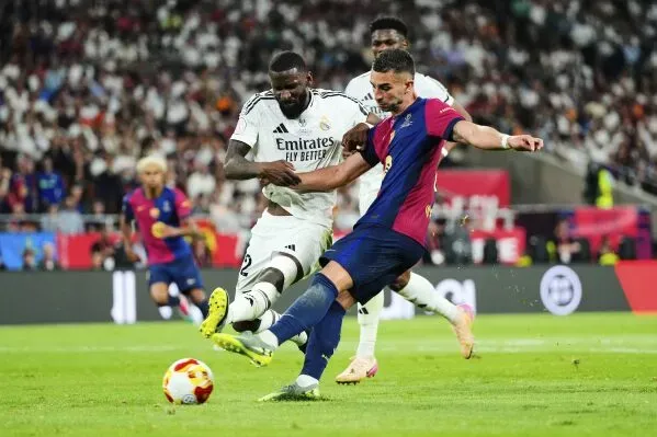 أنطونيو روديجر من ريال مدريد يتدخل ضد لاعب برشلونة خلال مباراة كأس الملك، وسط أجواء تنافسية عالية.