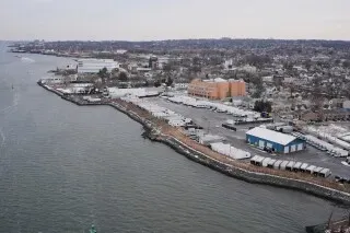 منظر جوي لواجهة بحرية في مدينة نيويورك، يظهر المباني والمرافق على ضفاف المياه، مع التركيز على التغيرات في تقسيم الدوائر الانتخابية.