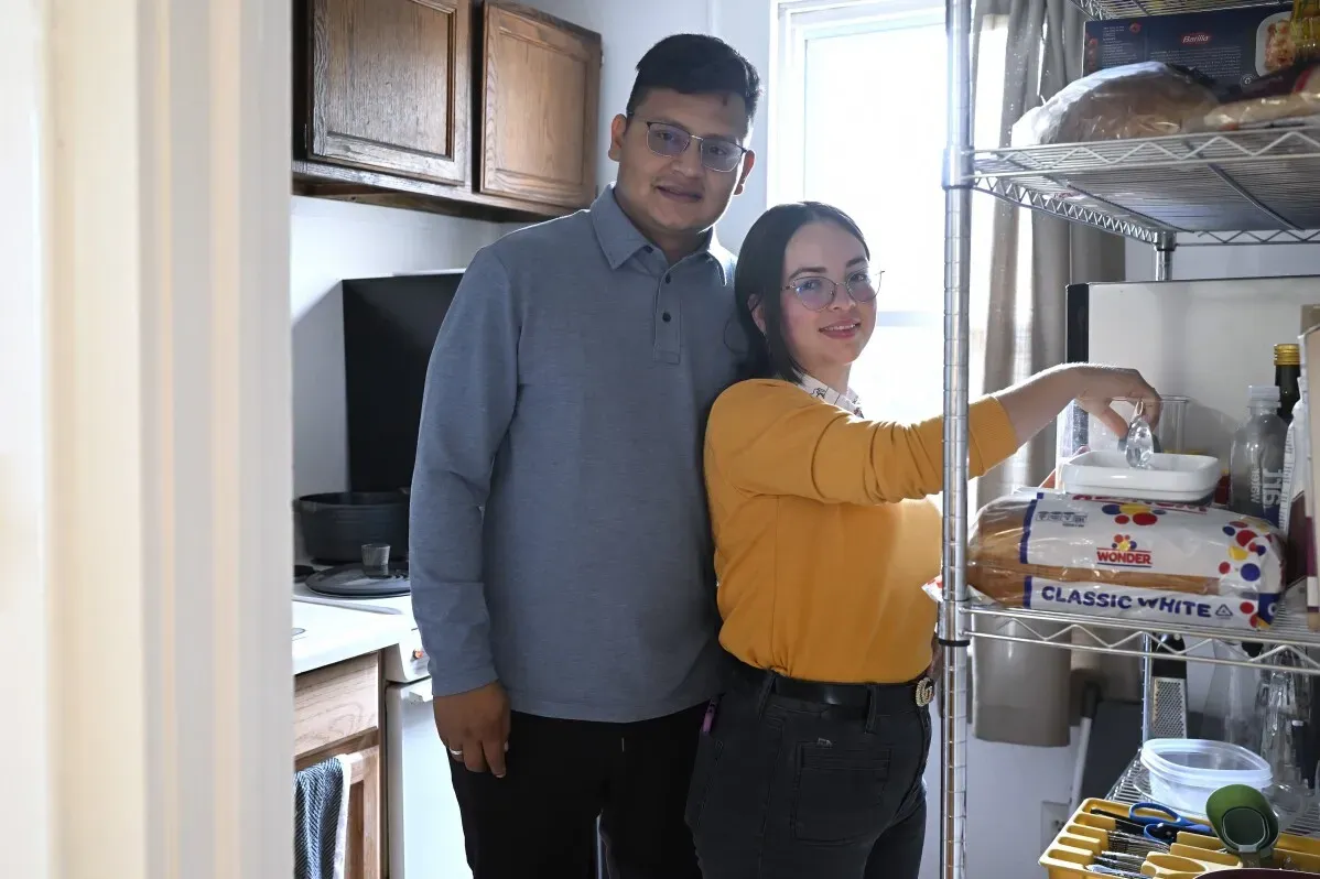 عائلة لوبيز-كانيزاريز في المطبخ بشقتهم الجديدة، تتطلع بإيجابية لبداية حياة جديدة كلاجئين في كونيتيكت وسط دعم المجتمع.