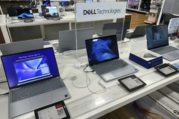 أجهزة كمبيوتر محمولة من Dell تعرض في متجر إلكترونيات، مع لافتة توضح العلامة التجارية، تعكس اتجاهات الإنفاق في قطاع التكنولوجيا.