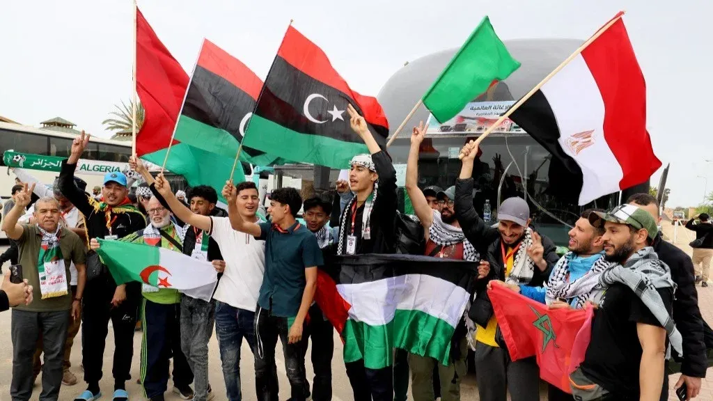 نشطاء من عدة دول يحملون أعلام فلسطين وليبيا ومصر، معبرين عن دعمهم للقضية الفلسطينية خلال قافلة إنسانية.