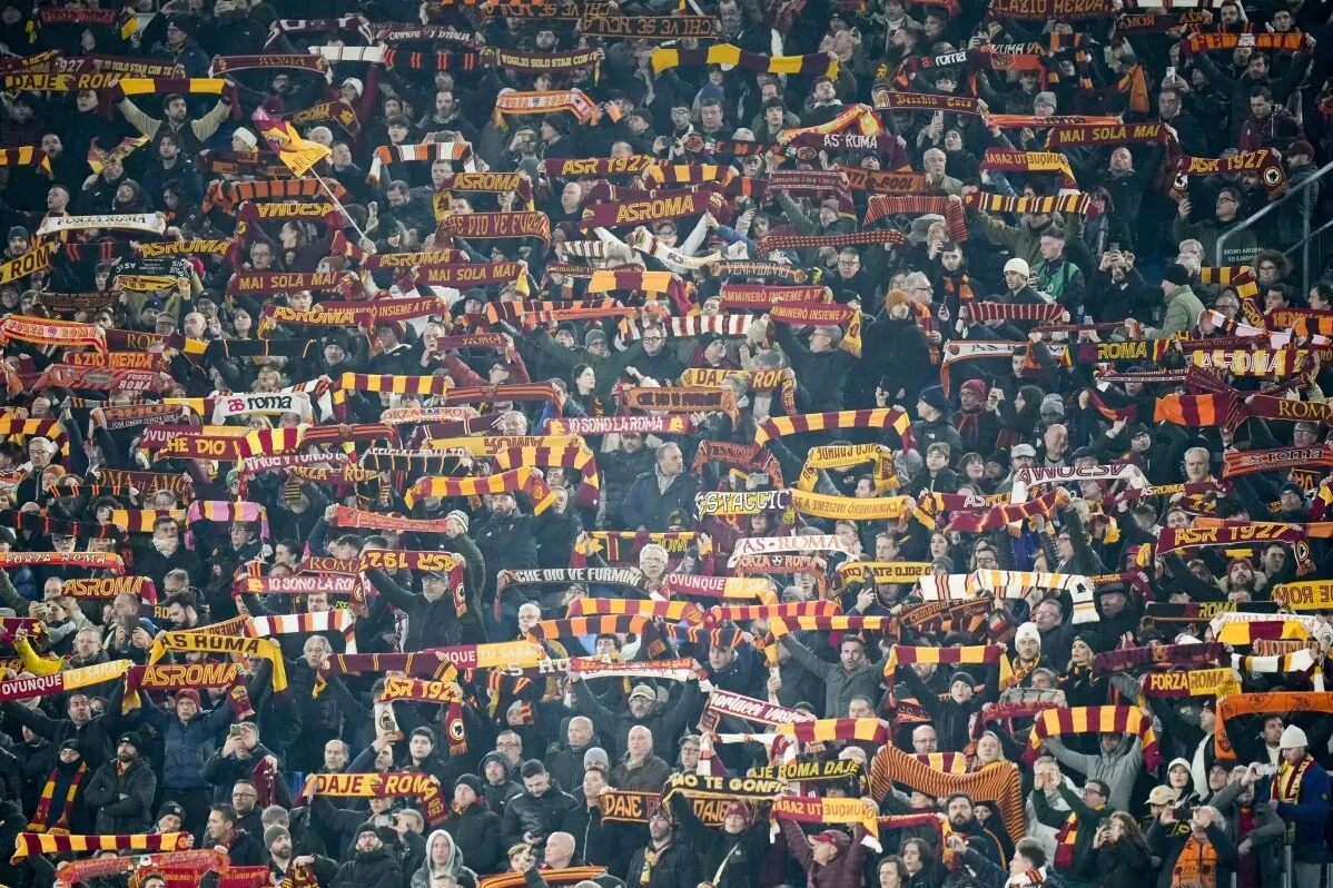 جماهير روما تحمل الأوشحة في ملعب الأوليمبيكو، تعبيرًا عن دعمهم للفريق في مباراة الدوري الأوروبي.
