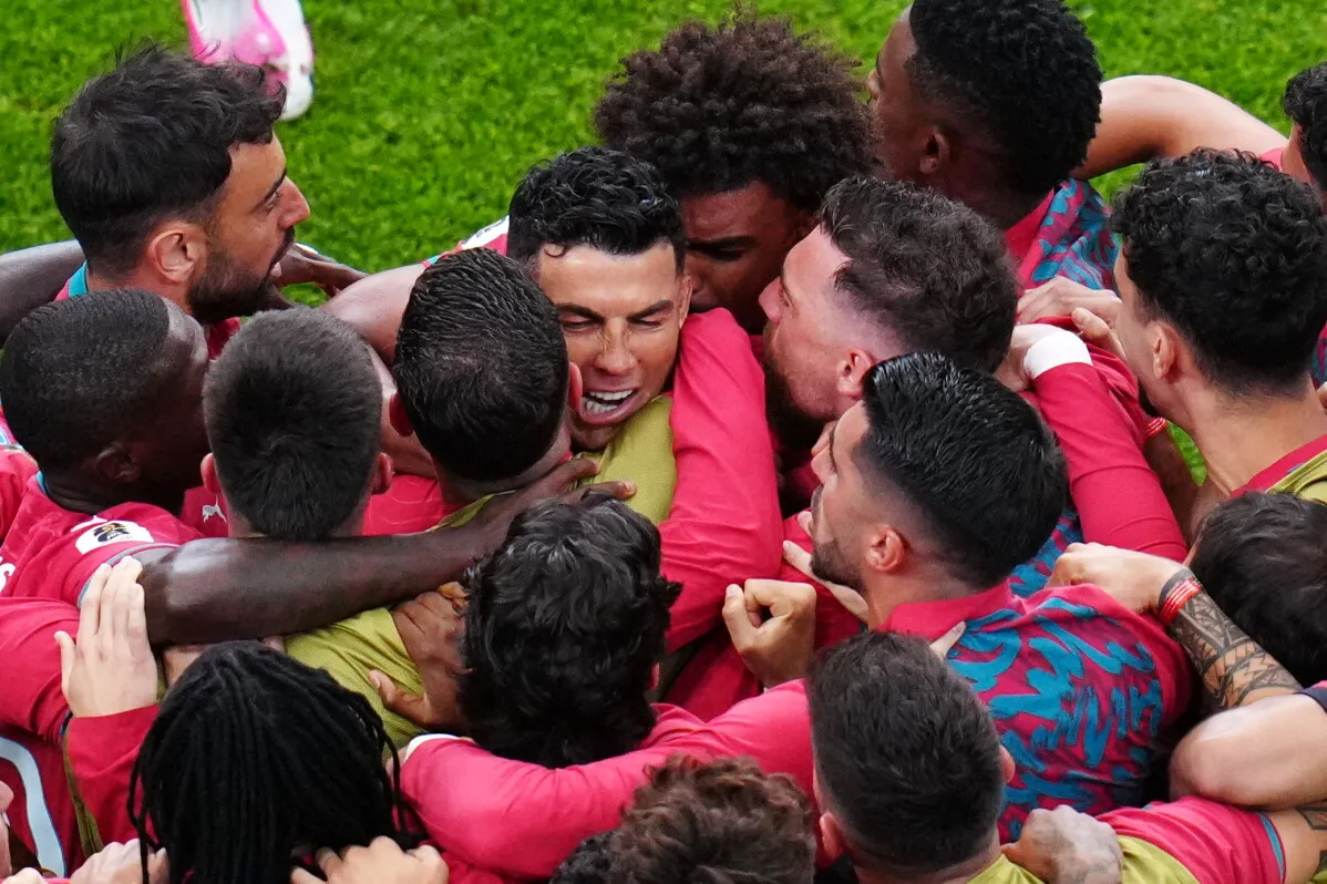 رونالدو محاط بزملائه في المنتخب البرتغالي، يحتفلون بعد تسجيل هدف، في أجواء حماسية قبل مواجهة كولومبيا في كأس العالم.