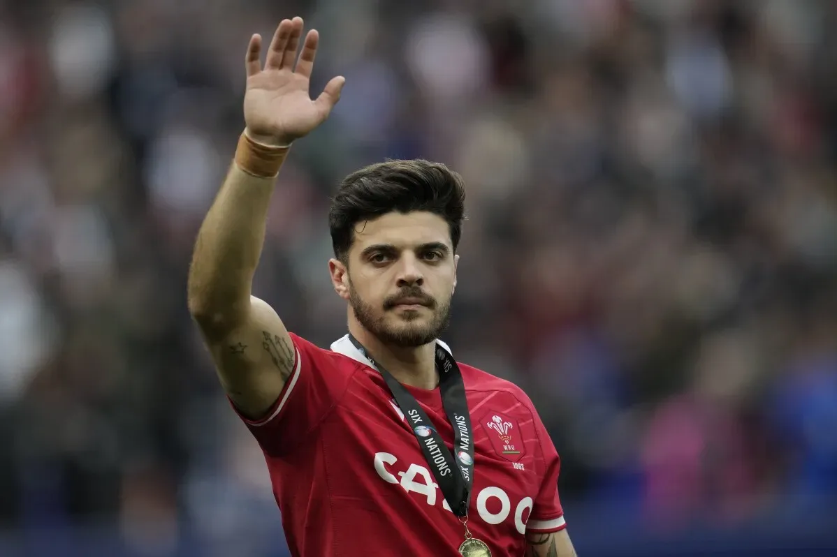 لاعب رغبي يرتدي قميصاً أحمر ويحيي الجماهير بعد مباراة، مع ميدالية على عنقه، في سياق استعدادات فرنسا لبطولة الأمم الست.