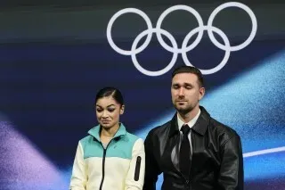 أديليا بيتروسيان، المتزلجة الروسية، تستعد للتنافس في أولمبياد ميلانو، مع خلفية شعار الألعاب الأولمبية.