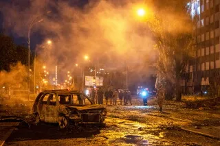 حطام سيارة محترقة وسط شارع مظلم في زاباروجيا بعد قصف روسي بقنابل شراعية تسبب في أضرار بشرية ومادية.