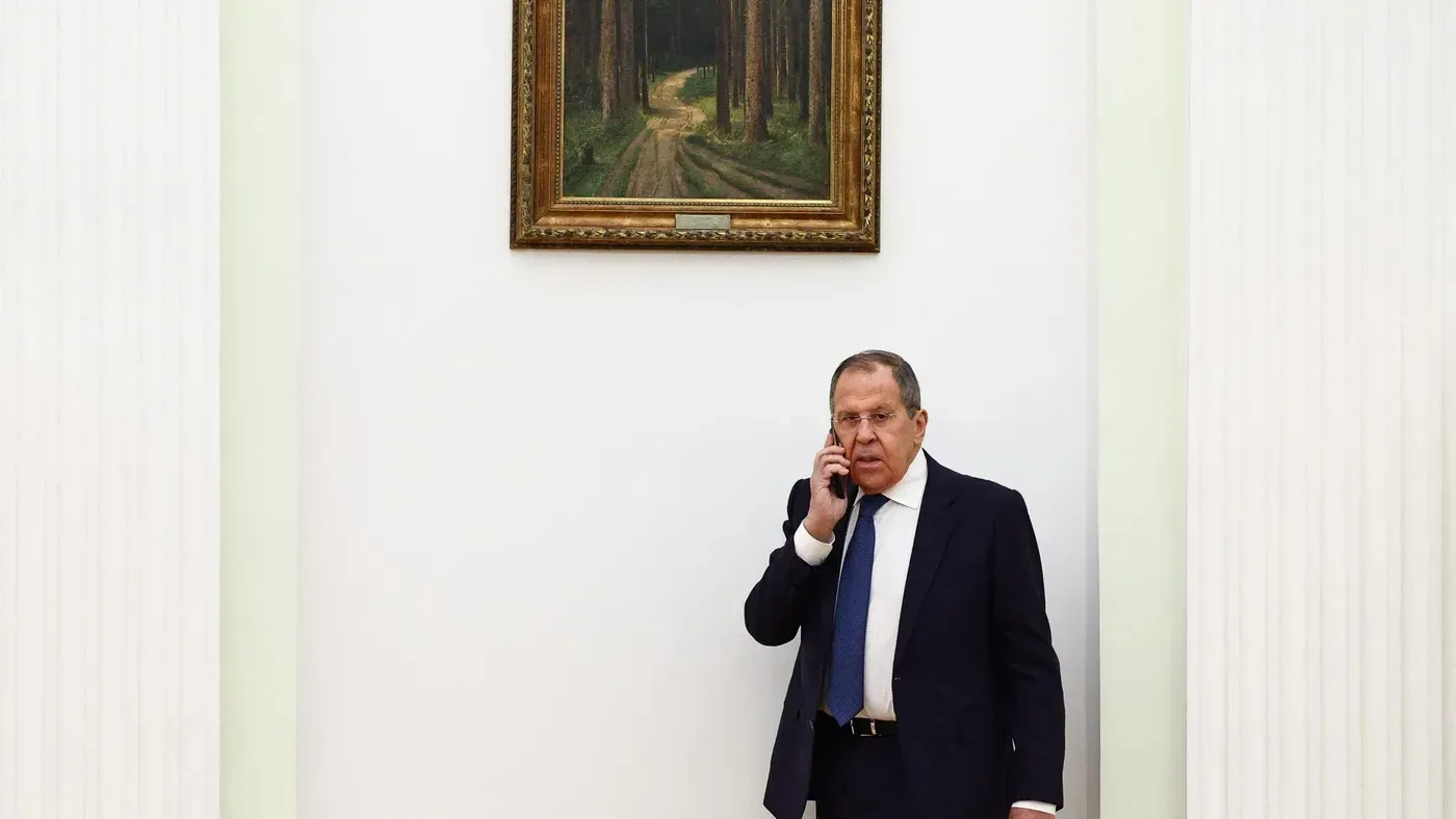 وزير الخارجية الروسي سيرغي لافروف يتحدث عبر الهاتف في قاعة رسمية، مع لوحة طبيعية خلفه، استعدادًا لزيارة تركيا.