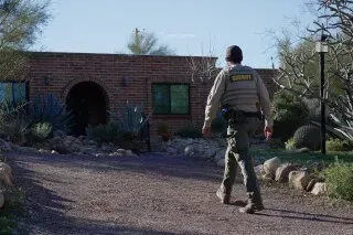 شرطي يسير نحو منزل نانسي غوثري في توسون، أريزونا، حيث تجري التحقيقات في اختفائها الغامض وسط مخاوف من صحتها.