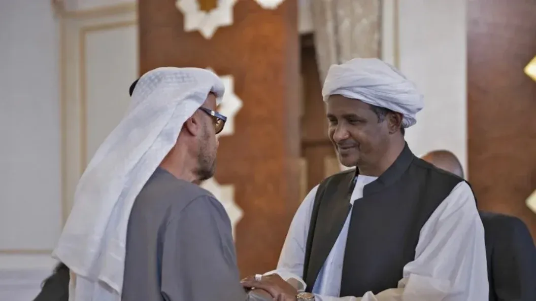 مسؤولان إماراتيان يتصافحان خلال لقاء رسمي يعكس دور الإمارات في دعم قوات الدعم السريع وسط اتهامات بارتكاب فظائع في دارفور.