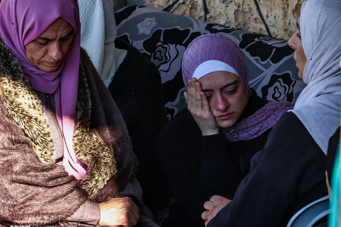 أفراد من عائلة فلسطينية يجلسون في حزن بعد مقتل أحد أقاربهم جراء غارة جوية إسرائيلية في الضفة الغربية المحتلة.