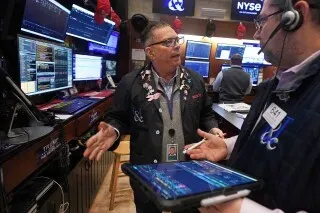 تداولات في بورصة نيويورك تُظهر متداولين يتناقشون حول الأسهم، مع شاشات تعرض بيانات السوق، في ظل تراجع أسهم الذكاء الاصطناعي وارتفاع أسعار النفط.