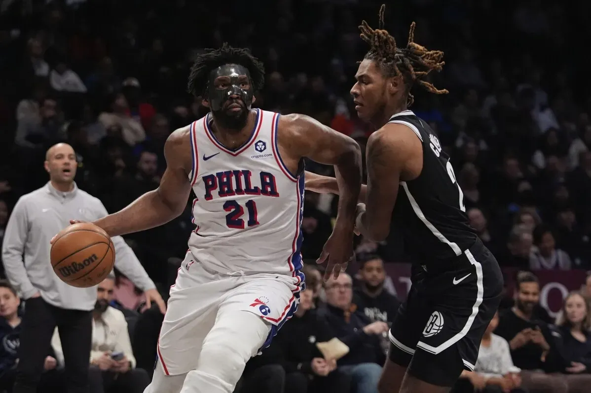 جويل إمبيد، لاعب فيلادلفيا 76ers، يسجل نقطة بينما يتعرض لمراقبة من لاعب منافس، في سياق إصابته الأخيرة.