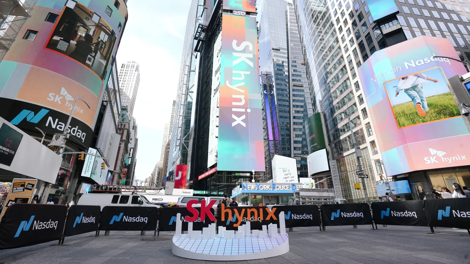 شعار SK Hynix بارز في ميدان تايمز سكوير بنيويورك مع شاشات رقمية تعلن إدراج الشركة في بورصة ناسداك، في سياق توسعها العالمي واستثماراتها في تصنيع رقائق الذاكرة.