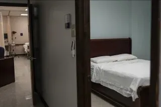 غرفة نوم بسيطة تحتوي على سرير مرتب، تُظهر بيئة مريحة للنوم، تتعلق بتكنولوجيا تتبع النوم وأهميتها.