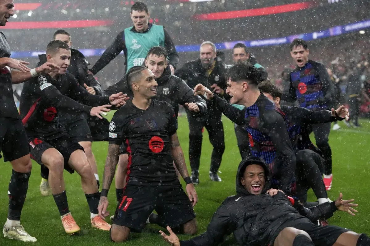 فريق برشلونة يحتفل بفوزه على بنفيكا 5-4 في دوري أبطال أوروبا، بينما تنهمر الأمطار حولهم.