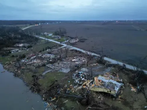 مشهد جوي يظهر الأضرار الواسعة التي خلفتها الأعاصير في إلينوي، حيث دُمرت منازل وأشجار، مع بقايا حطام متناثرة على الأرض.