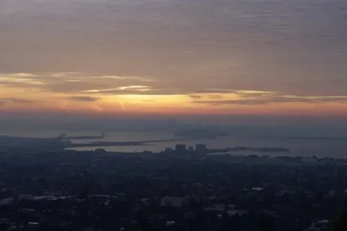 غروب الشمس فوق منطقة خليج سان فرانسيسكو، مع ظهور المباني والجبال في الأفق، يعكس الهدوء بعد زلزال بقوة 4.3 درجة.