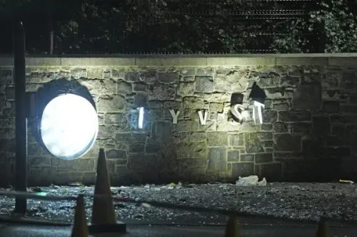 حطام على جدار فندق سيتي ويست بعد اشتباكات بين الشرطة ومحتجين مناهضين للمهاجرين بالقرب من دبلن، مع وجود أضواء ساطعة وأعلام.