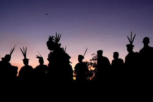silhouettes لأعضاء مجتمع الأشانينكا الأصلي في الأمازون مع زخارف رأس تقليدية، تعبير عن مقاومتهم للحفاظ على أراضيهم من تهديدات تهريب المخدرات والعنف.