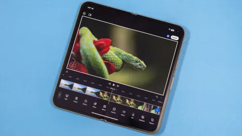 هاتف أندرويد قابل للطي يعرض واجهة تطبيق Adobe Premiere للمونتاج مع فيديو لثعبان على زهرة، يبرز أدوات تحرير الفيديو المجانية.
