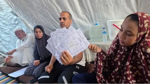 عائلة فلسطينية في غزة تعرضت لخسائر كبيرة بعد قصف منزلهم، يظهر رجل يحمل وثائق رسمية وسط أفراد عائلته في خيمة مؤقتة.