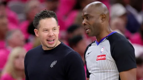 صورة تظهر مدرباً يتحدث مع حكم خلال مباراة NBA، مع شعار طيران الإمارات على زي الحكم، تعكس الشراكة بين NBA والإمارات.