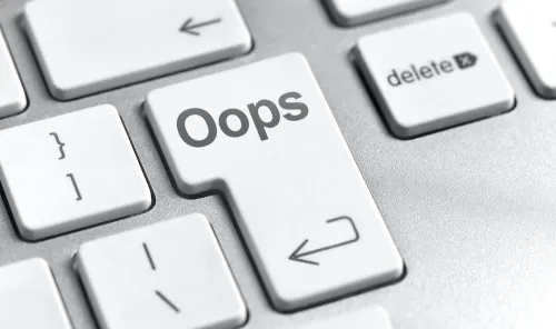 لوحة مفاتيح حاسوب مع مفتاح إدخال مكتوب عليه "Oops" يرمز إلى خطأ في الذكاء الاصطناعي وتأثيره على القرارات العسكرية.