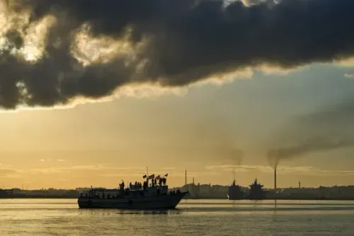 سفينة تحمل مساعدات إنسانية تقترب من رصيف هافانا، مع غيوم داكنة في السماء، تعكس الأزمة الاقتصادية والطاقة في كوبا.