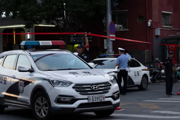 تظهر الصورة سيارات شرطة أمام موقع حادثة اصطدام طائرة صغيرة ببرج CITIC في بكين، مع وجود شرطة تقوم بتأمين المنطقة.