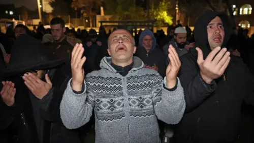 تجمع عدد من الرجال في صلاة جماعية، يرفعون أيديهم للدعاء في أجواء رمضانية، تعبيرًا عن التمسك بالهوية الفلسطينية وسط القيود.