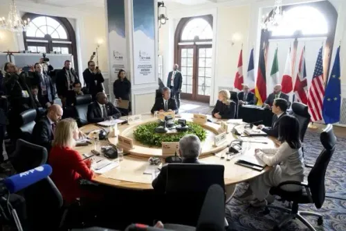 اجتماع وزراء خارجية مجموعة السبع في لا مالباي، كيبيك، حيث يناقشون قضايا دولية مهمة، مع وجود أعلام الدول المشاركة في الخلفية.