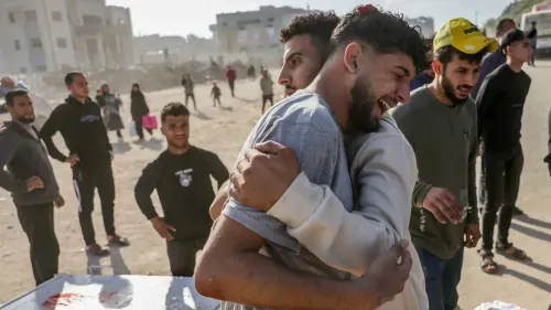 رجال فلسطينيون يحتضنون بعضهم في لحظة حزن بعد الهجمات على غزة، حيث تبدو المشاعر واضحة على وجوههم وسط الدمار.