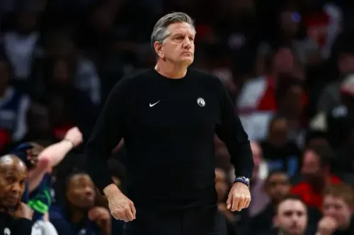 مدرب مينيسوتا تمبروولفز، كريس فينش، يبدو جادًا أثناء المباراة، مع تفاعل الجمهور خلفه، في سياق خسارة الفريق أمام أتلانتا هوكس.