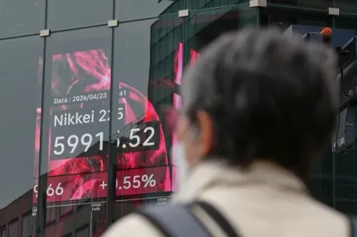 شخص يقف أمام شاشة تعرض بيانات مؤشر Nikkei 225 الياباني، مع تسجيل ارتفاع بنسبة 1% عند 5991.52 نقطة.