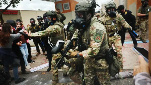 اشتباك بين عناصر من قوات الأمن ومحتجين خلال مظاهرة، مع وجود أفراد يرتدون زيًا عسكريًا وأقنعة واقية.