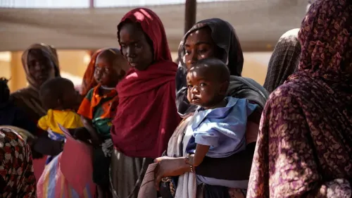 نساء وأطفال في الفاشر بالسودان ينتظرون الرعاية الصحية، وسط أزمة إنسانية بعد الهجمات على مستشفى الأمومة التعليمي.