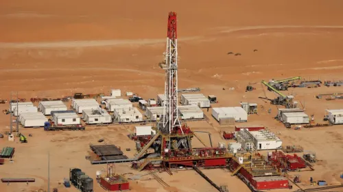 منشأة حفر نفطية في الصحراء السعودية، تظهر معدات الحفر والمباني، تعكس أهمية الطاقة في ظل الهجمات الإيرانية على البنية التحتية.