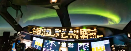 قمرة قيادة طائرة بوينغ 787 تحلق على ارتفاع 37,000 قدم فوق شمال مانيتوبا مع عرض الشفق القطبي الأخضر المضيء في السماء الليلية.