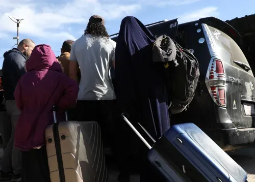 مجموعة من الأشخاص، بينهم نساء وأطفال، يستعدون للصعود إلى سيارة في شمال سوريا، بعد إطلاق سراحهم من مخيم الروج.