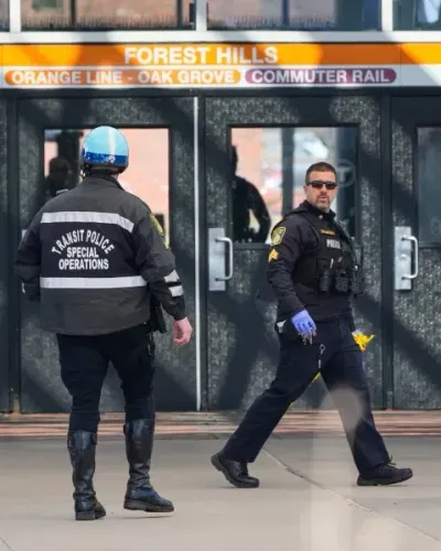 شرطيان في محطة فورست هيلز في بوسطن بعد حادثة تهديد بسكين جزار، مع وجود تعزيزات أمنية في المنطقة.