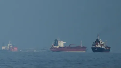 سفن شحن تبحر في مياه مضيق هرمز، مما يعكس تأثيرات الحرب على إيران والضغوط على أسعار النفط العالمية.