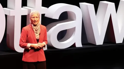 أميرة الغوابي، ناشطة حقوقية، تتحدث أمام لافتة "أوتاوا" في فعالية تتعلق بمكافحة الإسلاموفوبيا، تعبيرًا عن قضايا العنصرية في كندا.