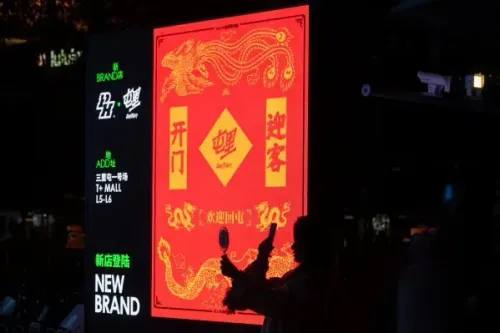 لافتة مضيئة حمراء تحمل رموزًا تقليدية وصورة تنين، تعكس أجواء الاحتفالات الصينية وتروّج لعلامة تجارية جديدة في بكين.