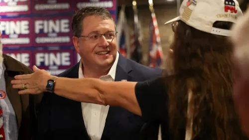 رجل في بدلة يتحدث مع مجموعة من الأشخاص في حدث سياسي، مع لافتات تحمل اسم "فاين" في الخلفية. الصورة تعكس أجواء الحملة الانتخابية في فلوريدا.