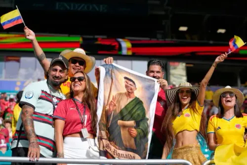 مجموعة من المشجعين في ملعب Miami Stadium يحملون لافتة تحمل صورة كريستيانو رونالدو، مع أجواء احتفالية خلال مباراة كولومبيا والبرتغال.